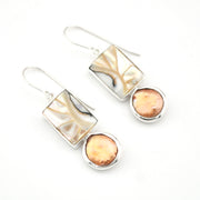 Pair of earrings with gold and silver designs on a white background