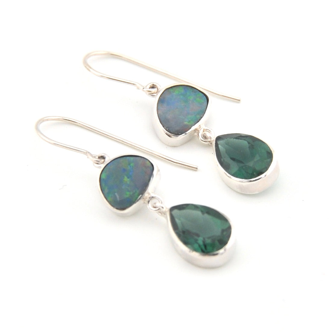 Pair of silver earrings with green gemstones on a white background