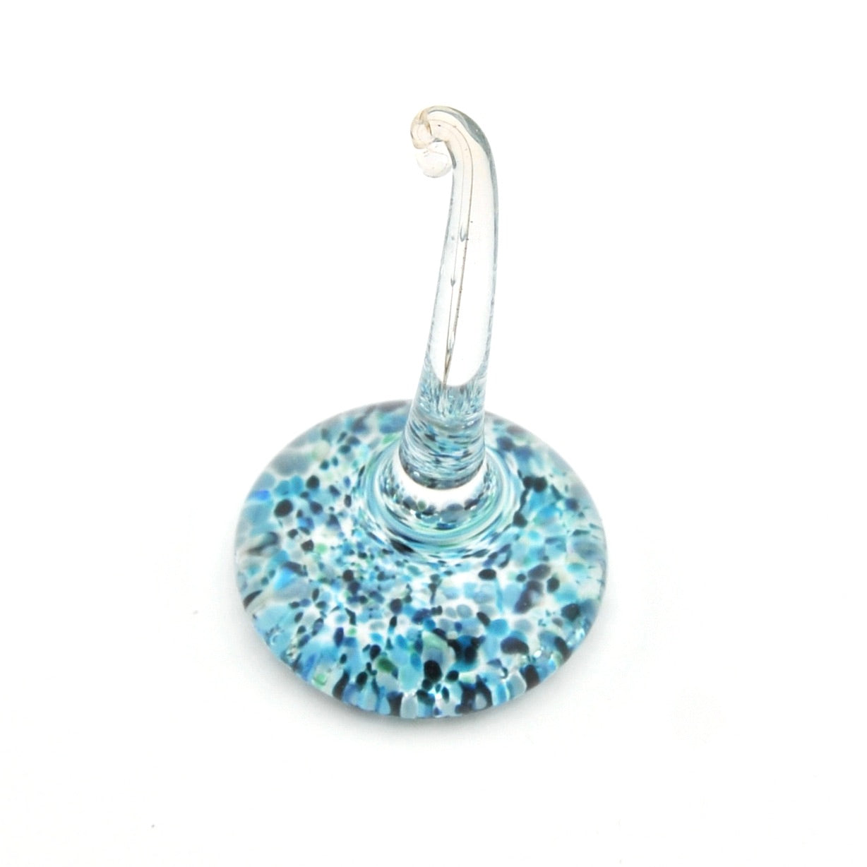 Glass ring holder with blue speckled base on a white background
