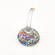 Multicolored speckled glass ring holder on a white background
