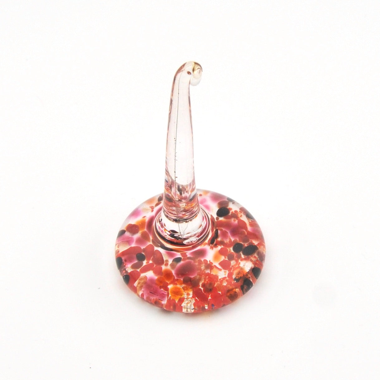 Decorative glass ring holder with a colorful base on a white background