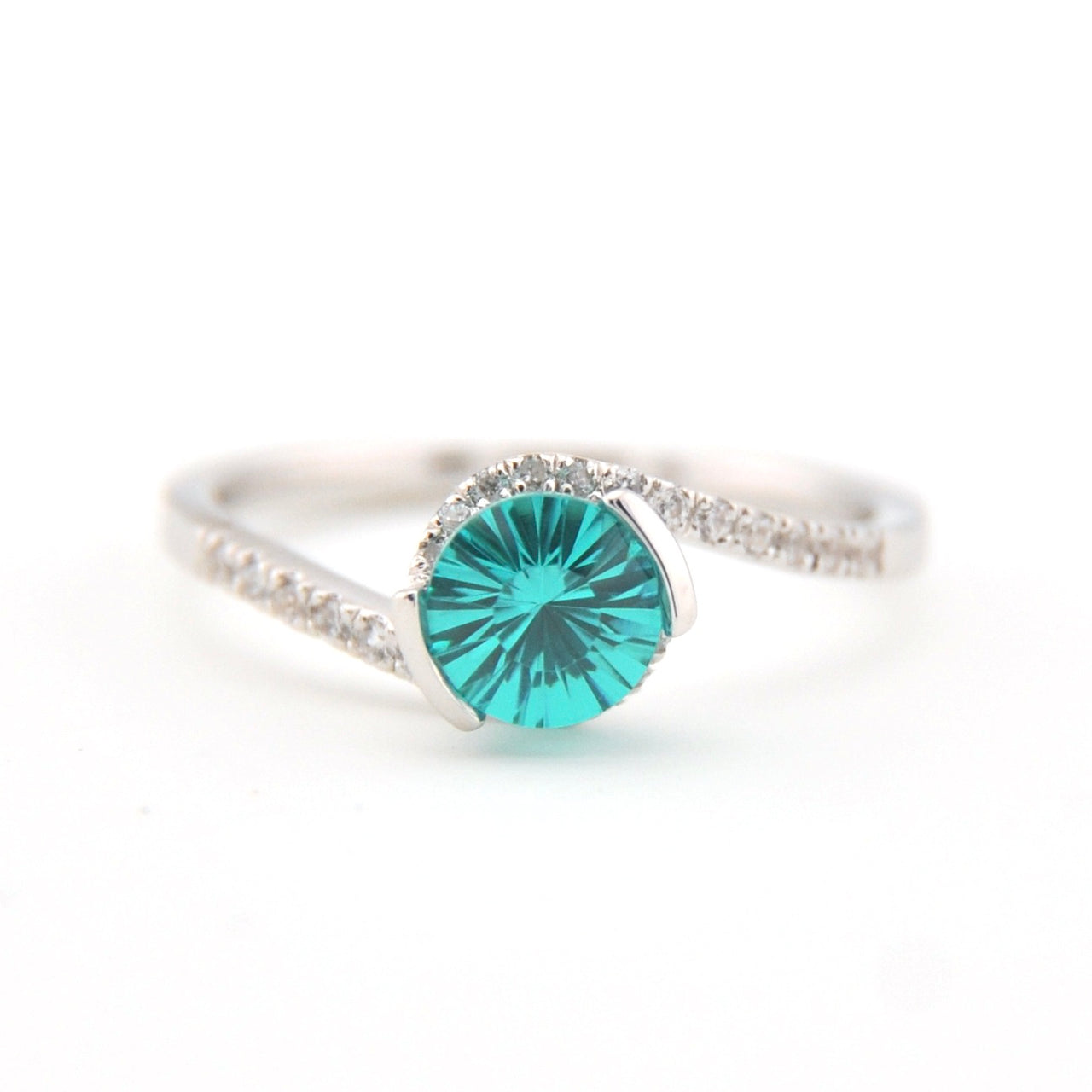 Silver ring with a teal gemstone on a white background