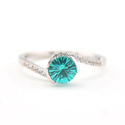 Silver ring with a teal gemstone on a white background