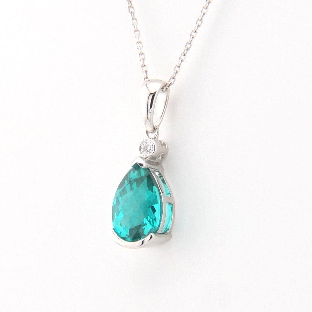 Teardrop-shaped blue gemstone pendant on a white background