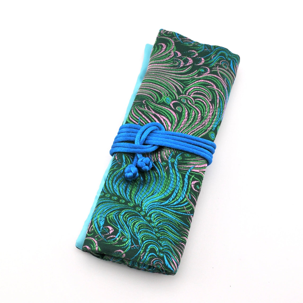 Folded fabric with a blue pattern and a blue cord tied around it on a white background