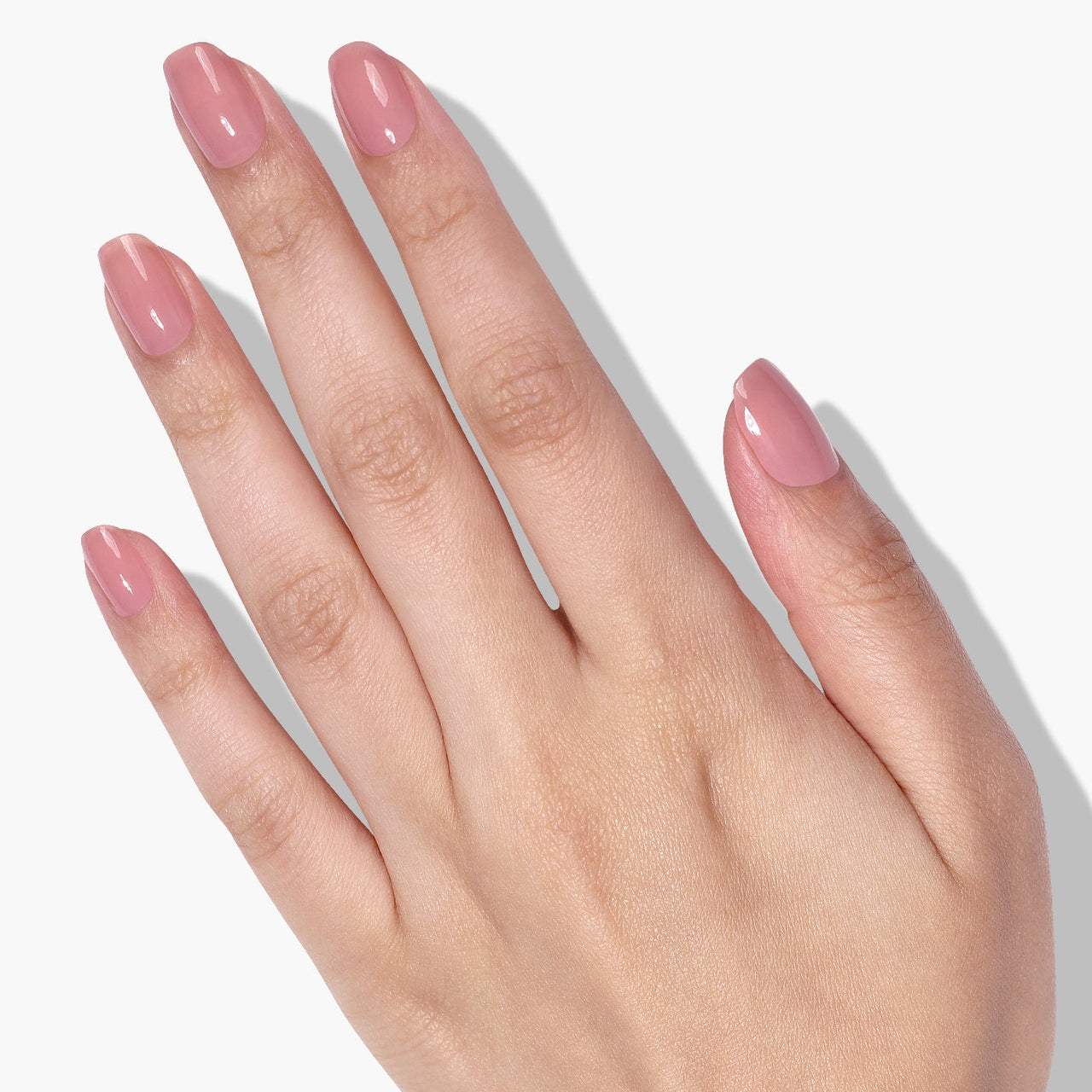Hand with pink nail polish on a white background