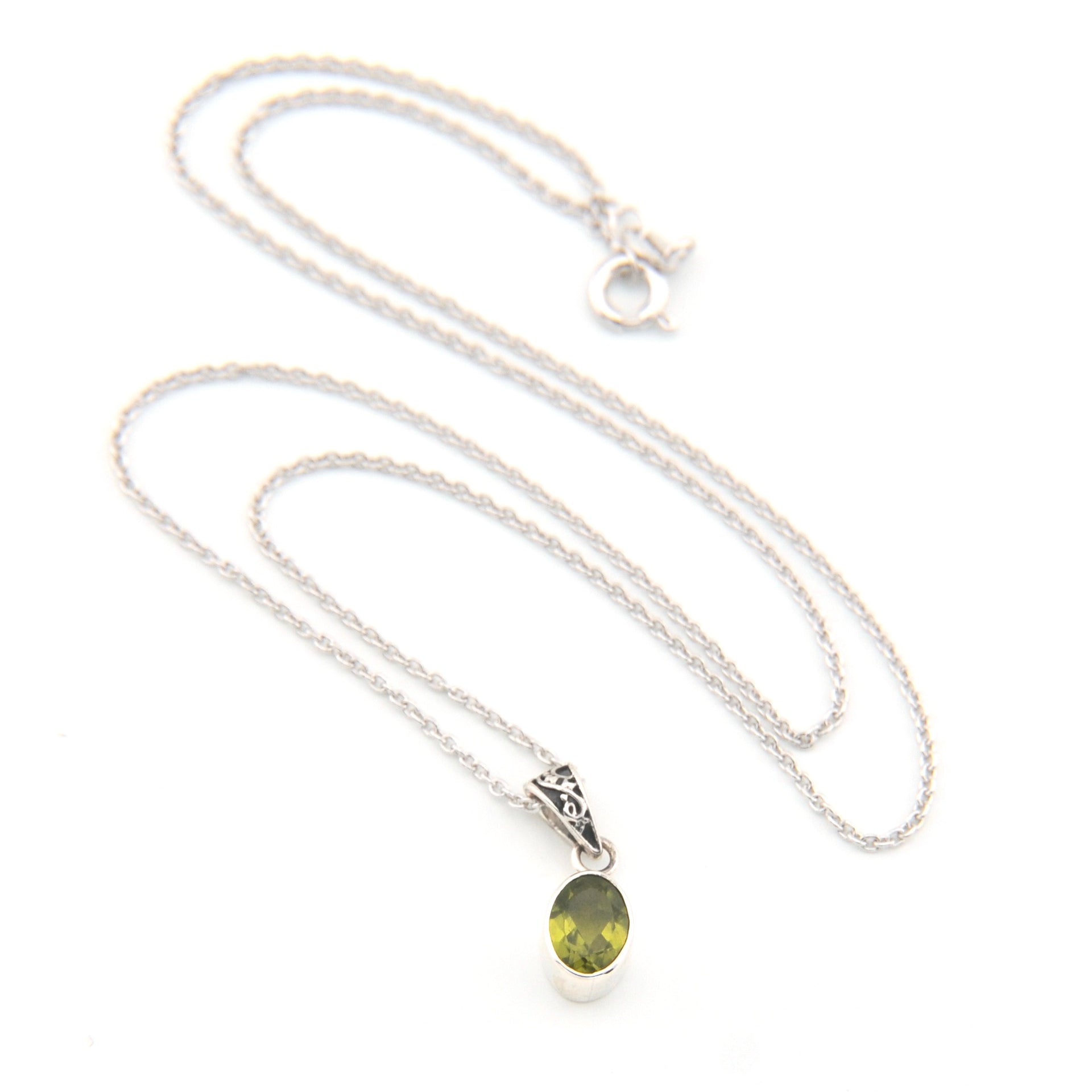 Silver necklace with a green pendant on a white background