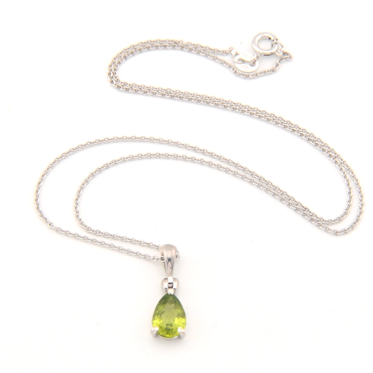Silver necklace with a green teardrop pendant on a white background