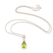 Silver necklace with a green teardrop pendant on a white background