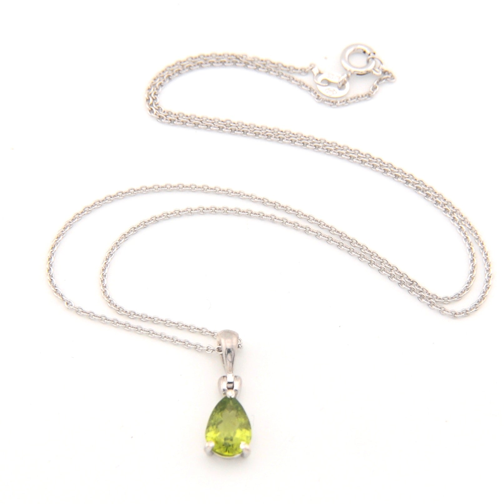 Silver necklace with a green teardrop pendant on a white background