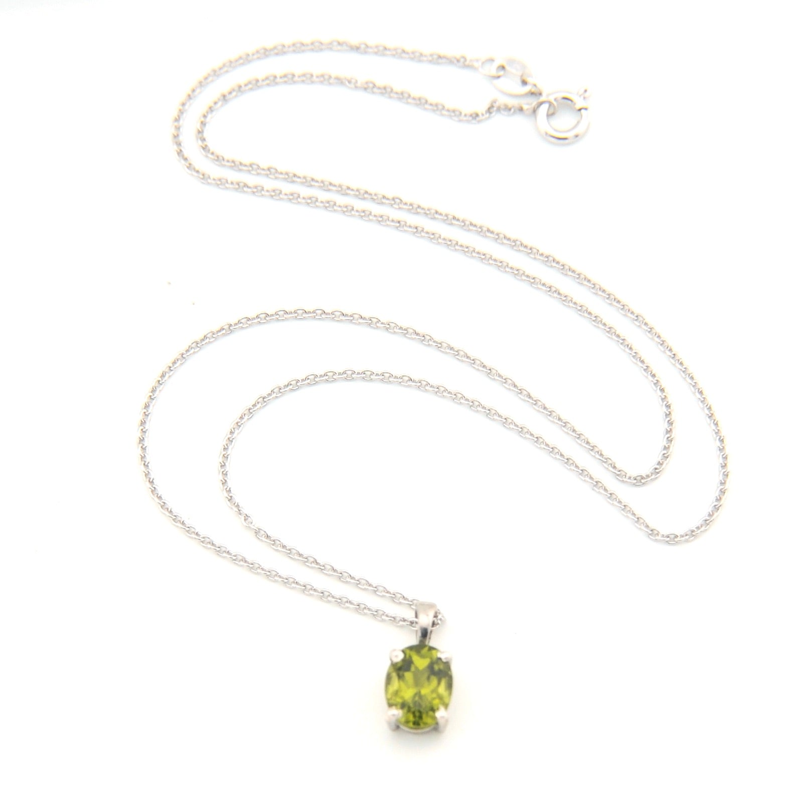 Silver necklace with a green pendant on a white background