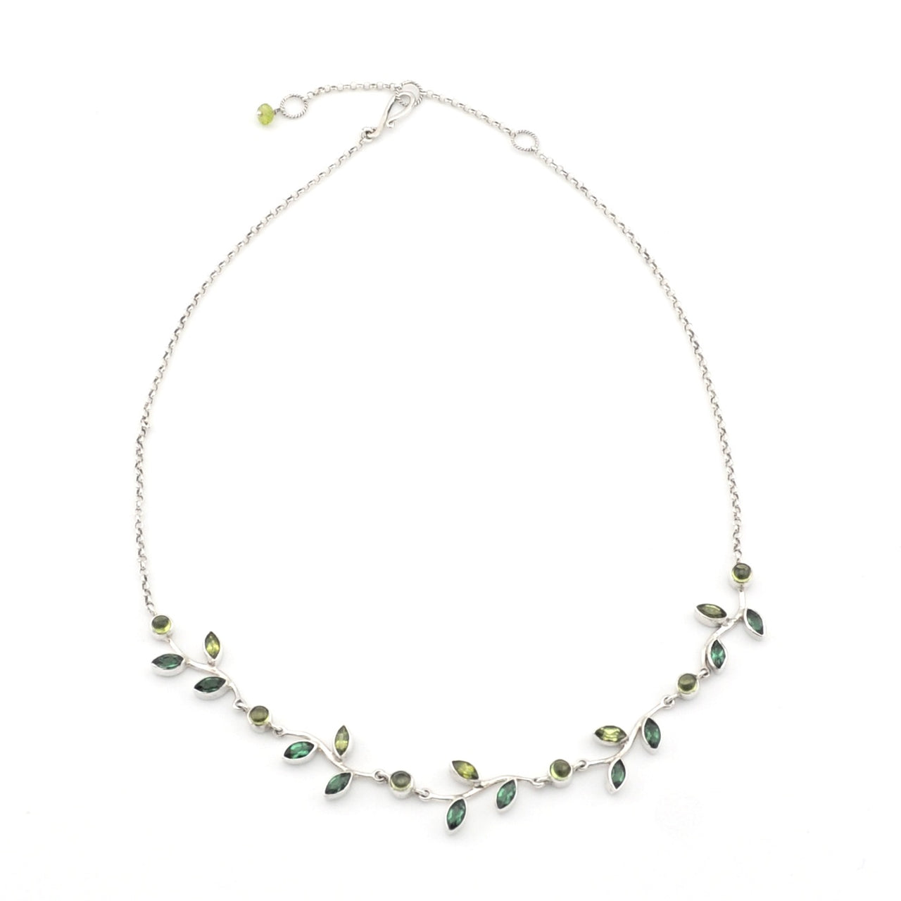 Silver necklace with green gemstones on a white background