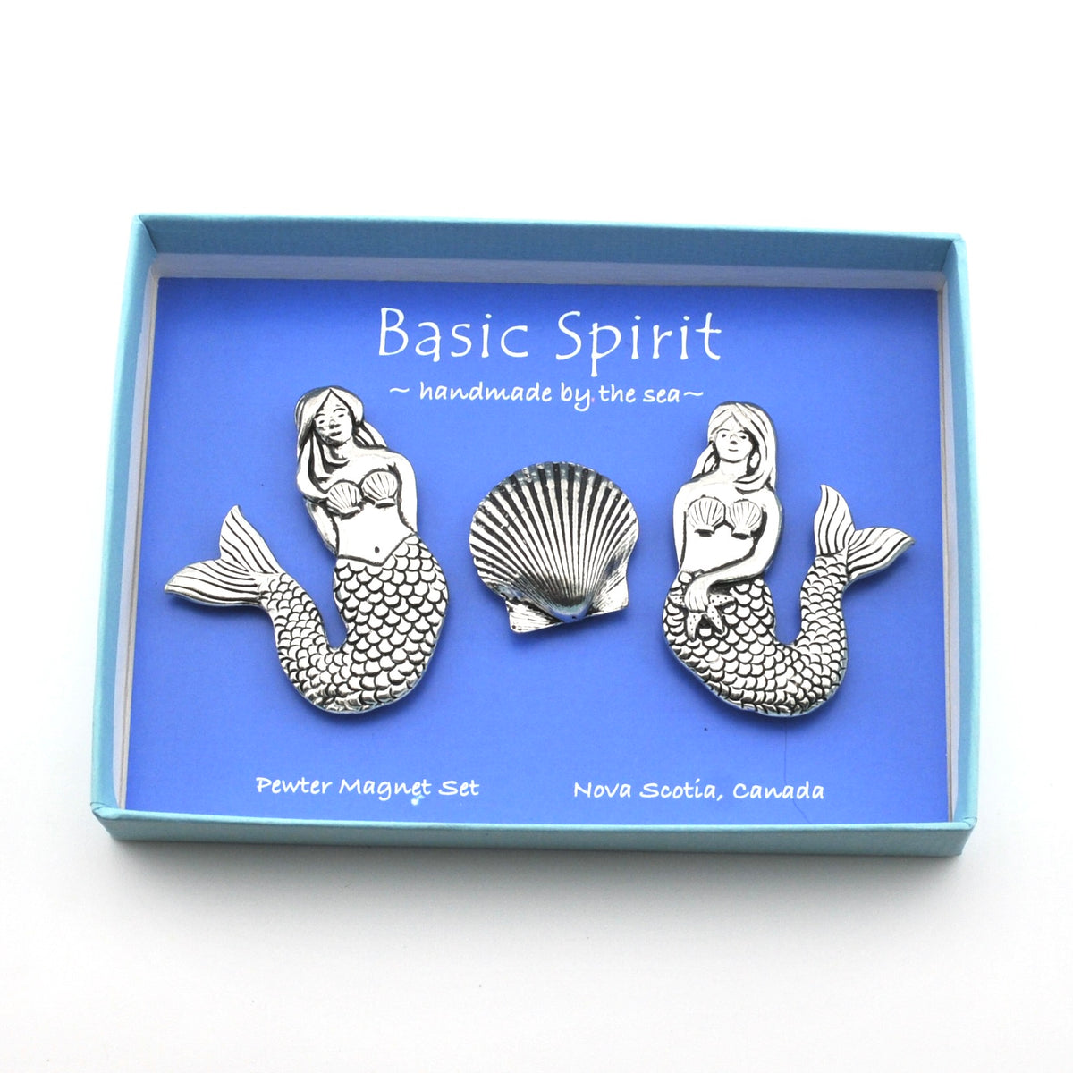 A mermaid-themed pewter magnet set by Basic Spirit, featuring two mermaid figures and a seashell, presented in a light blue box with a blue backing card.