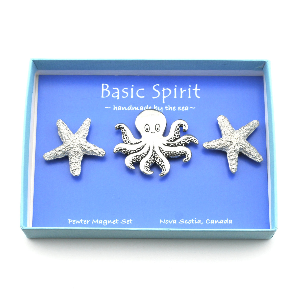 A three-piece pewter magnet set by Basic Spirit, featuring a central octopus and two starfish, displayed inside a light blue gift box with a blue insert card.