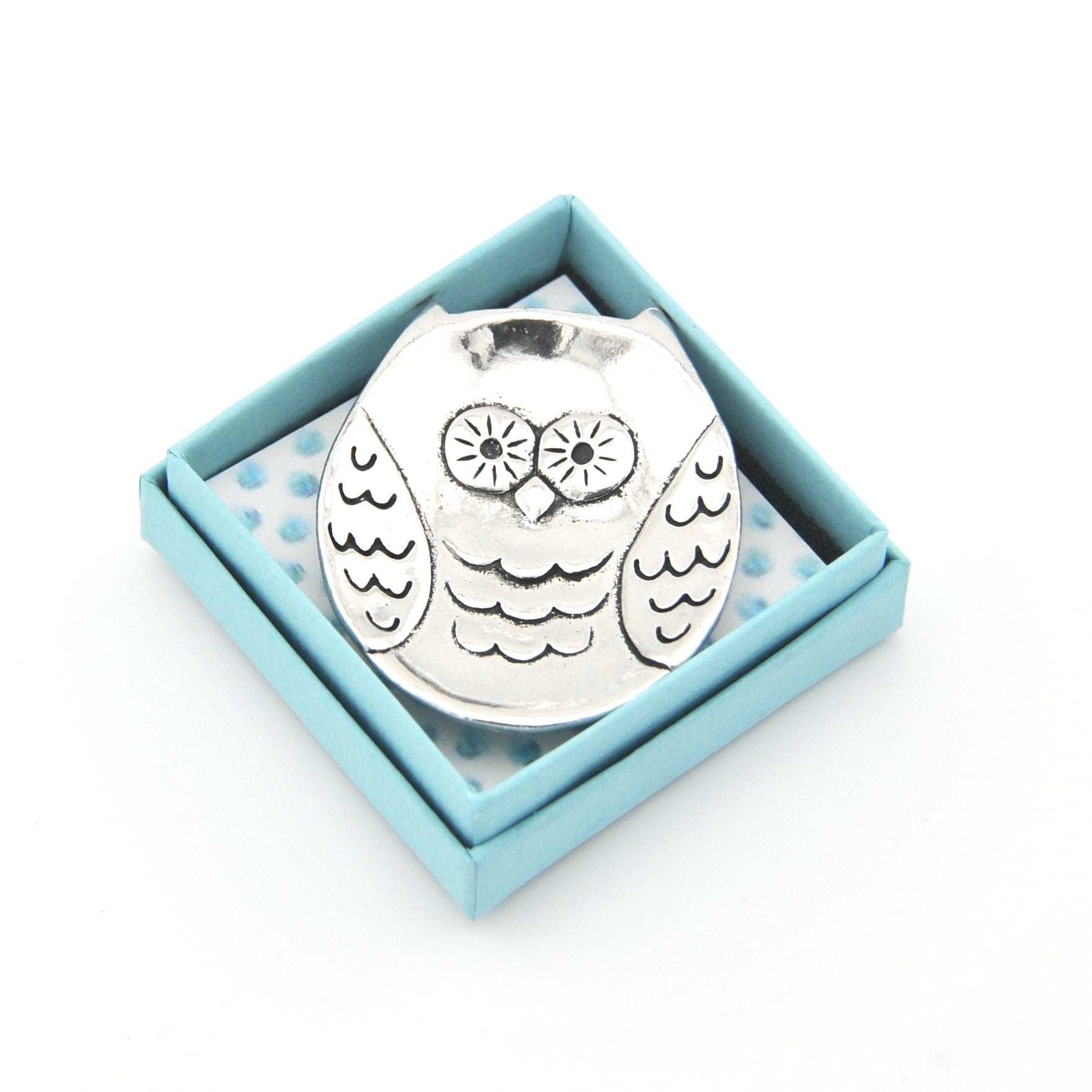 Silver owl-shaped object in a light blue box on a white background