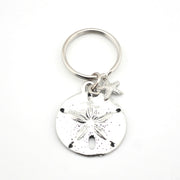 Silver keychain with sand dollar and starfish charms on a white background
