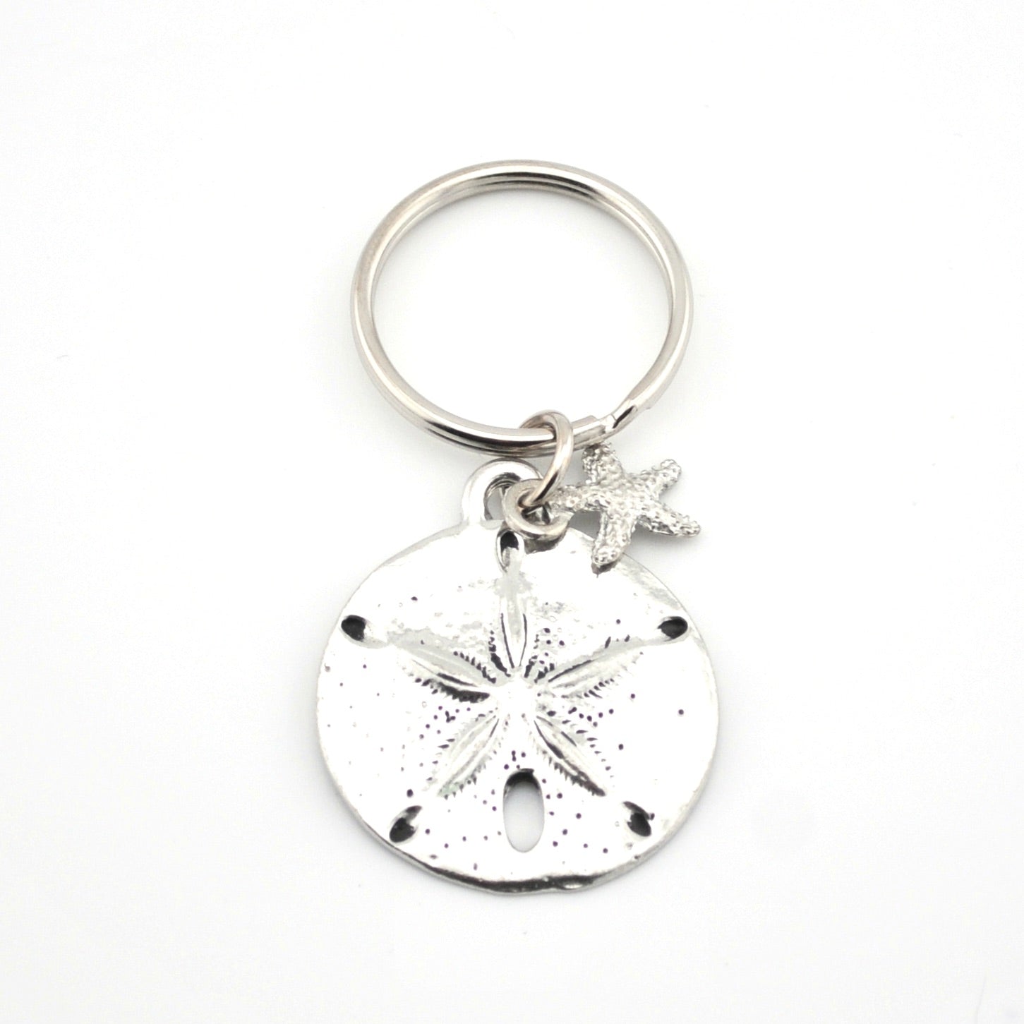 Silver keychain with sand dollar and starfish charms on a white background