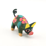 Colorful pig figurine with floral patterns on a white background