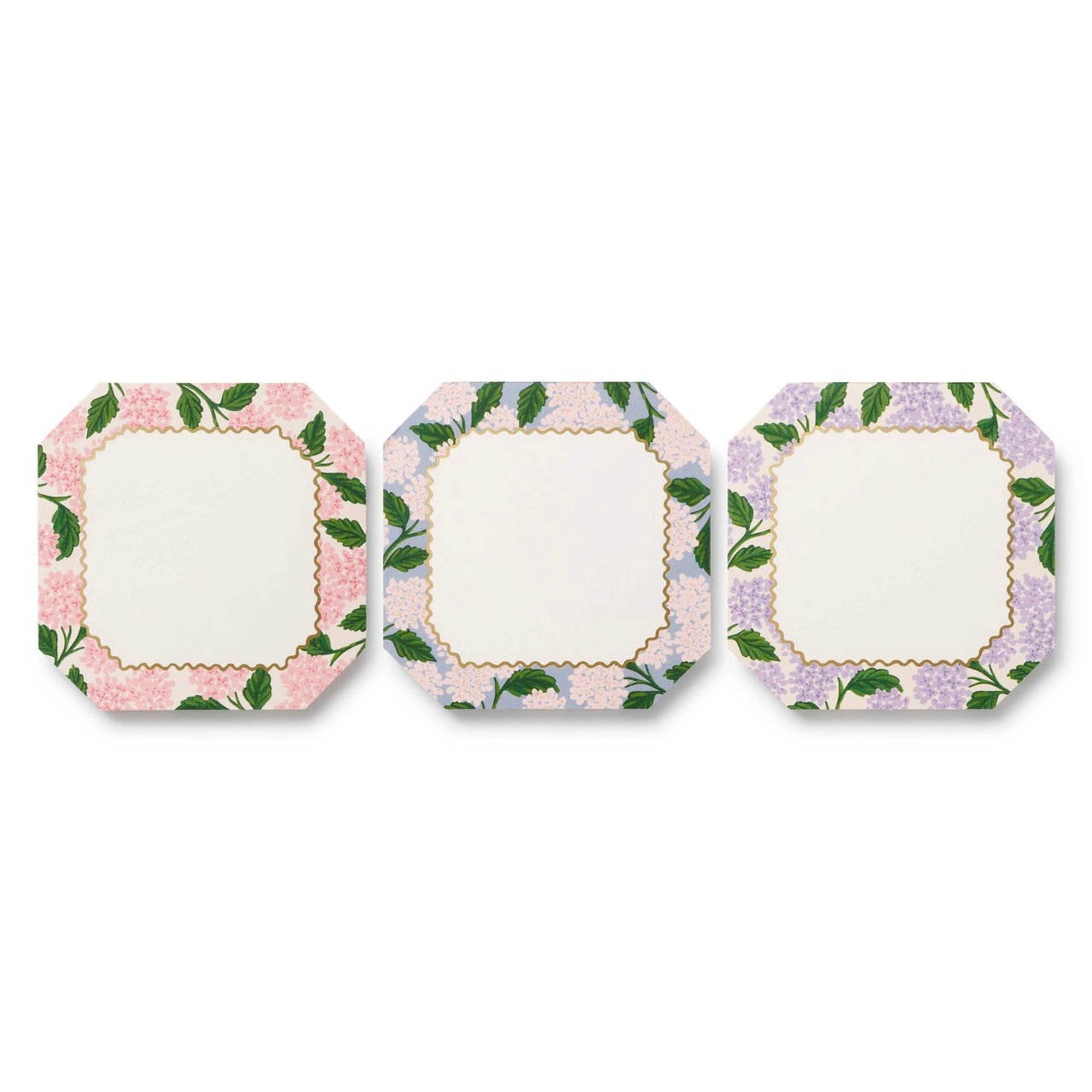 Three square plates with floral border designs on a white background