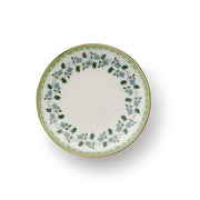 A round white porcelain plate with a delicate floral border design featuring light blue flowers, green leaves, and a scalloped green edge with a thin gold rim, shown from a top-down perspective on a white background.