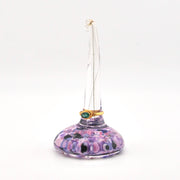 Purple glass ring holder with a ring on a white background