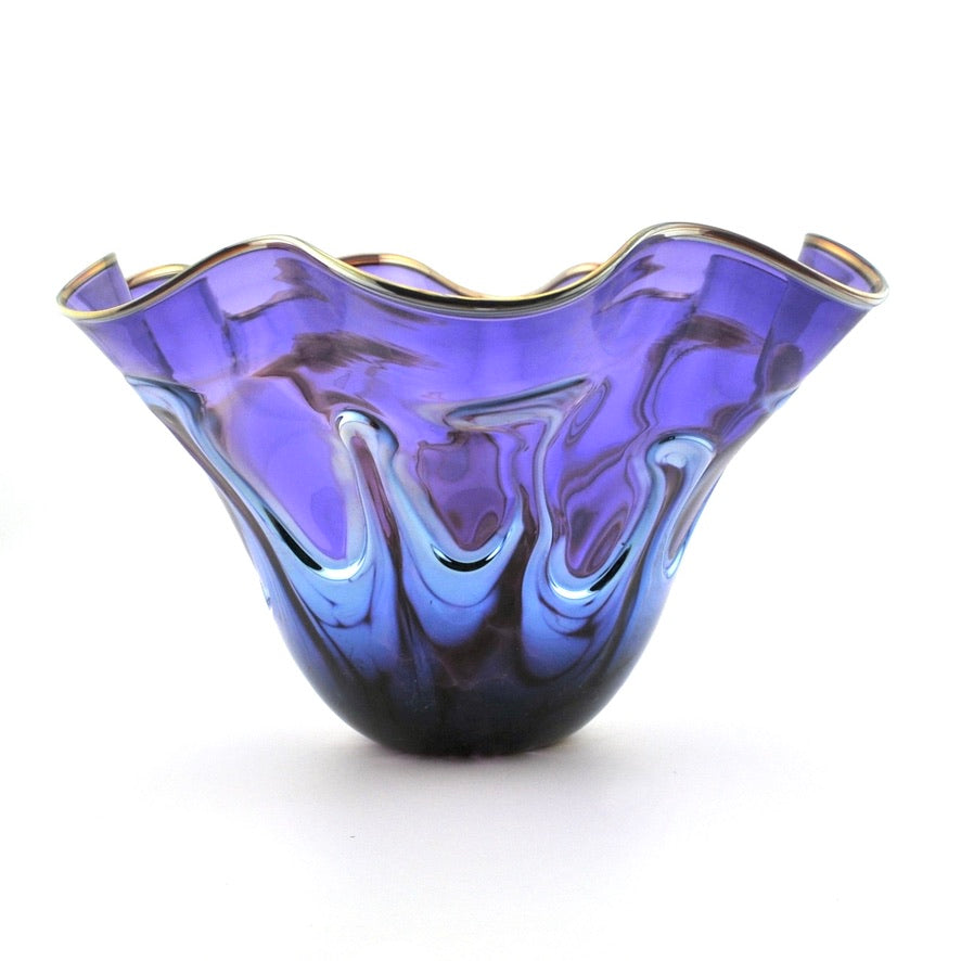 A purple and blue swirled glass bowl with a flared, scalloped rim and gold-toned edging, shown on a white background.