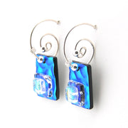 Pair of earrings with blue and clear glass pendants on a white background