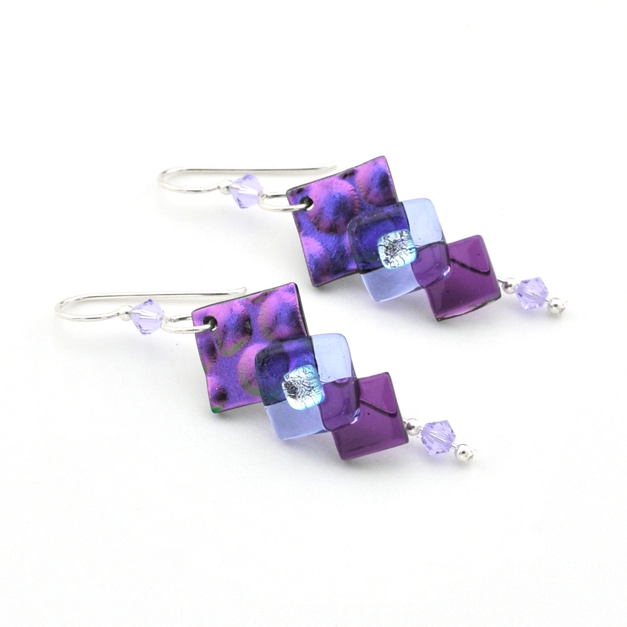 Pair of earrings with purple and blue square beads on a white background