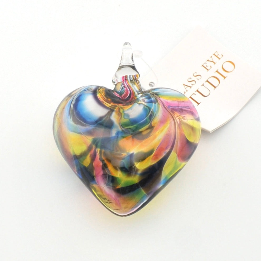 Colorful glass heart ornament with 'Glass Eye Studio' branding on a white background
