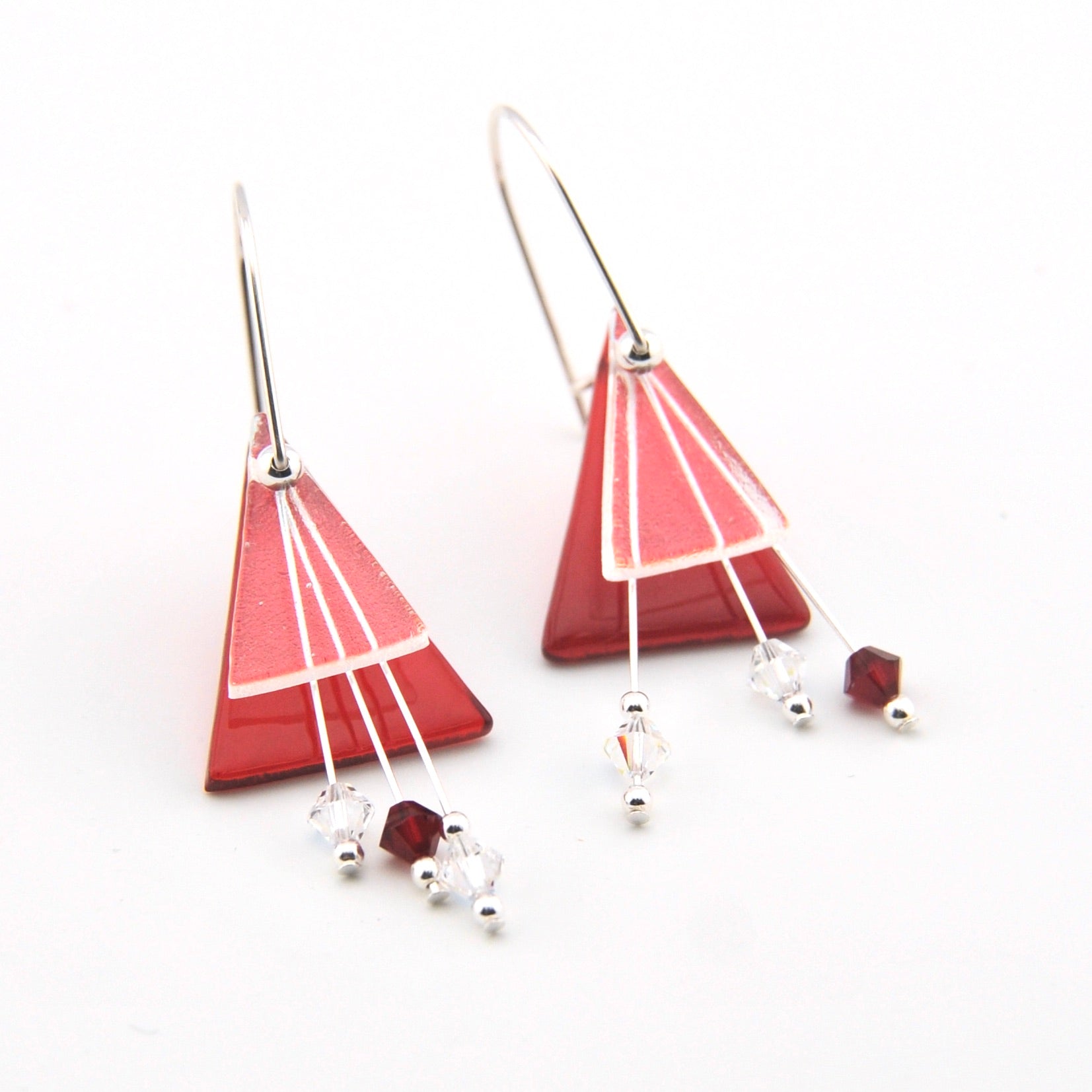 Triangular red earrings with white accents on a white background