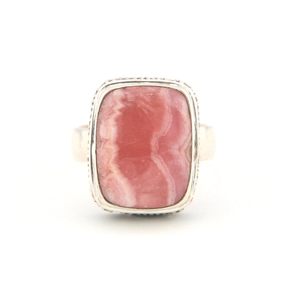 Ring with a pink stone and silver band on a white background