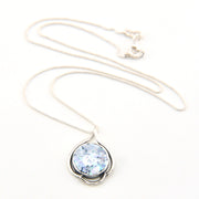 Necklace with a pendant featuring a blue gemstone on a white background