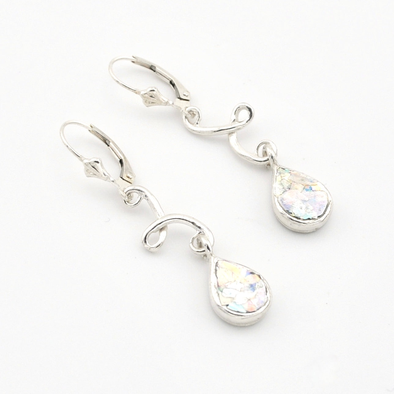 Silver teardrop earrings with Roman glass on a white background