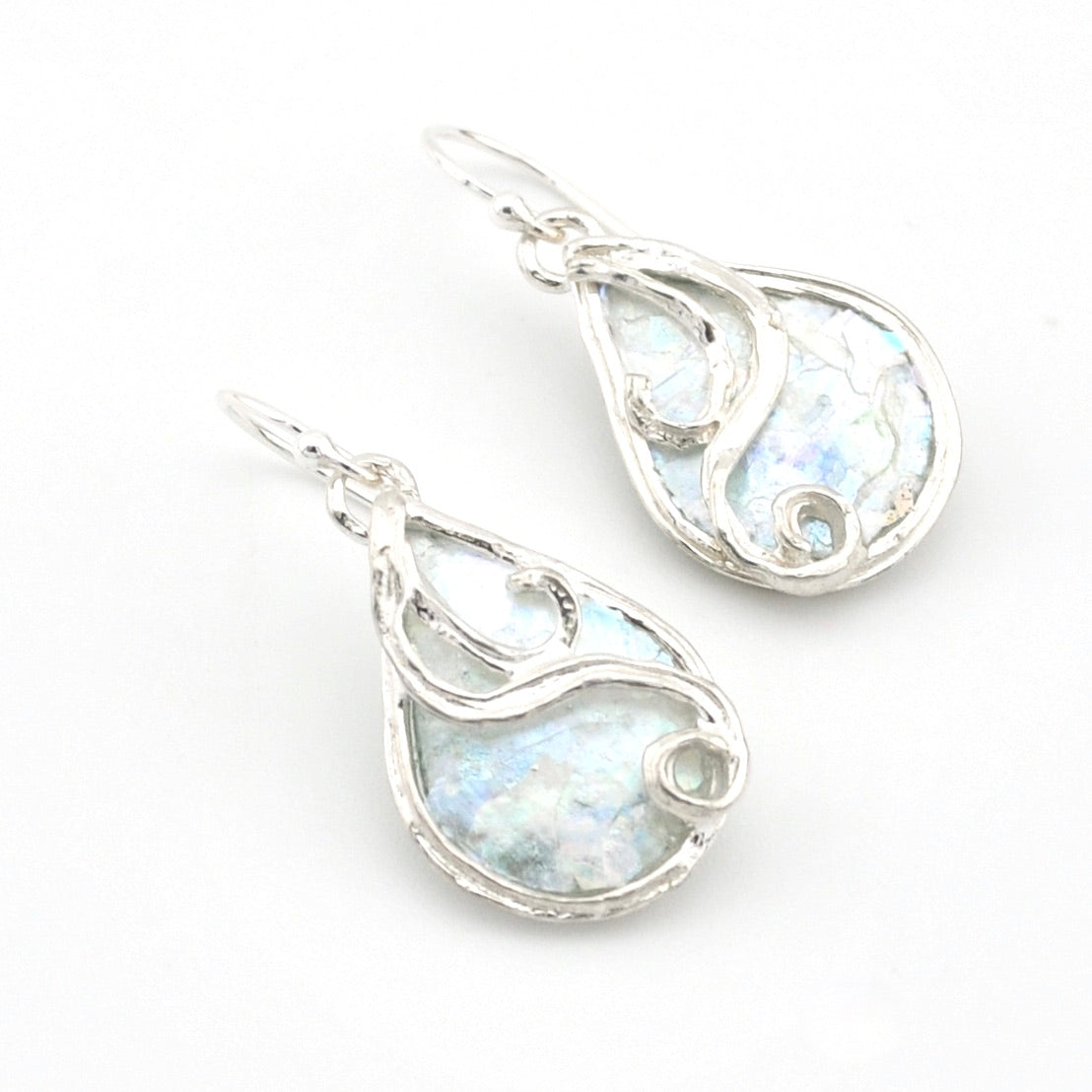 Silver teardrop earrings with a light blue Roman glass on a white background