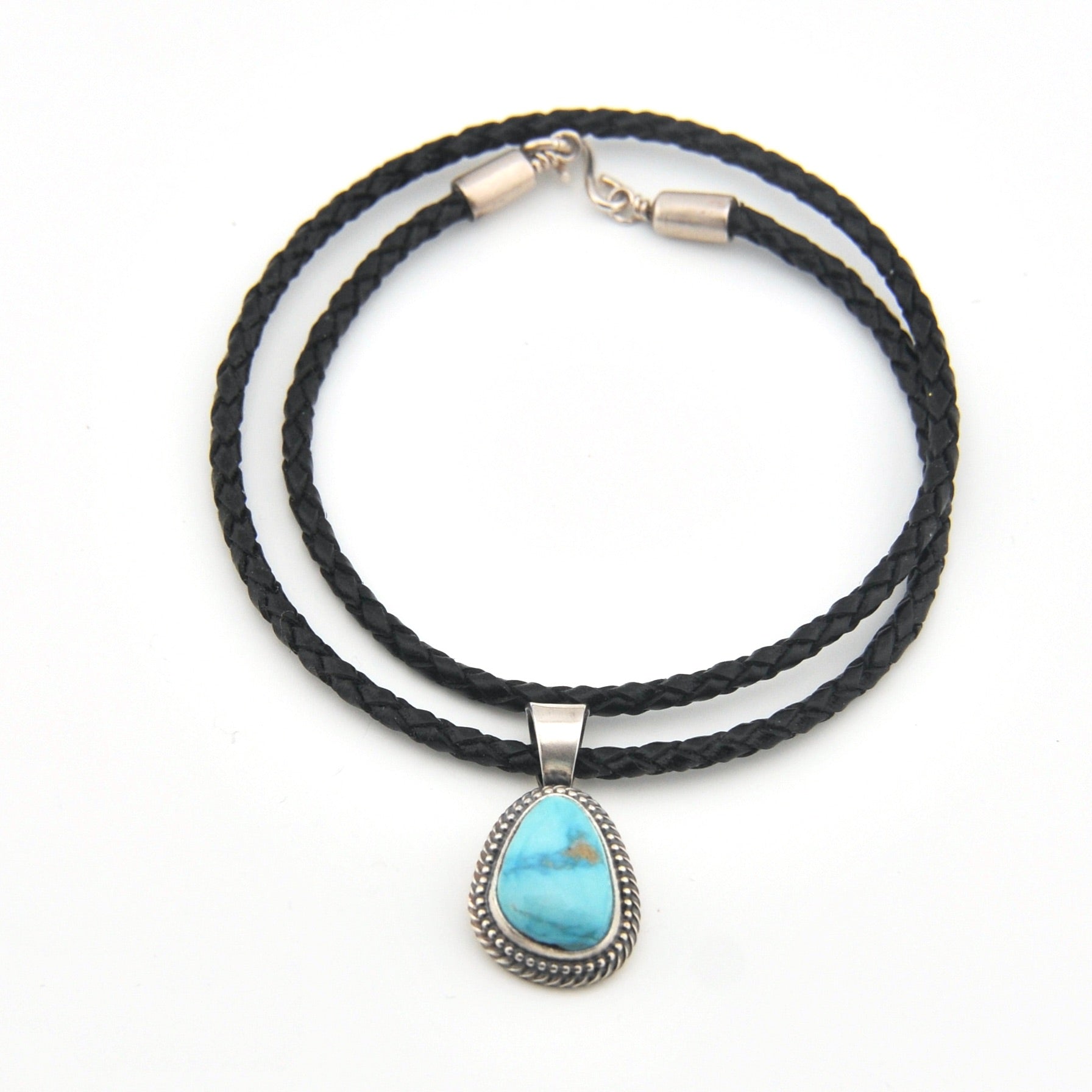 Black braided cord necklace with a turquoise stone pendant on a white background