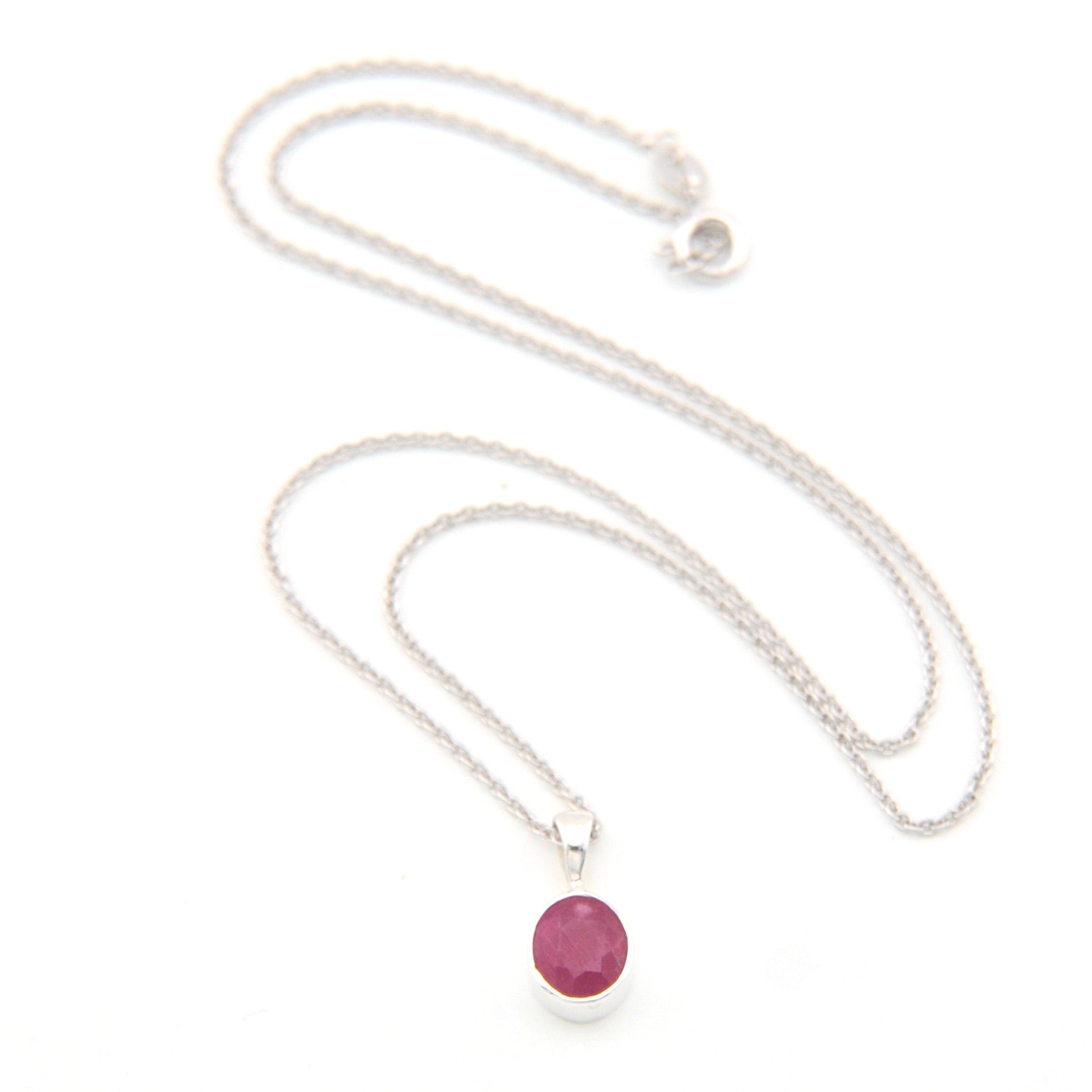 Silver necklace with a pink gemstone pendant on a white background