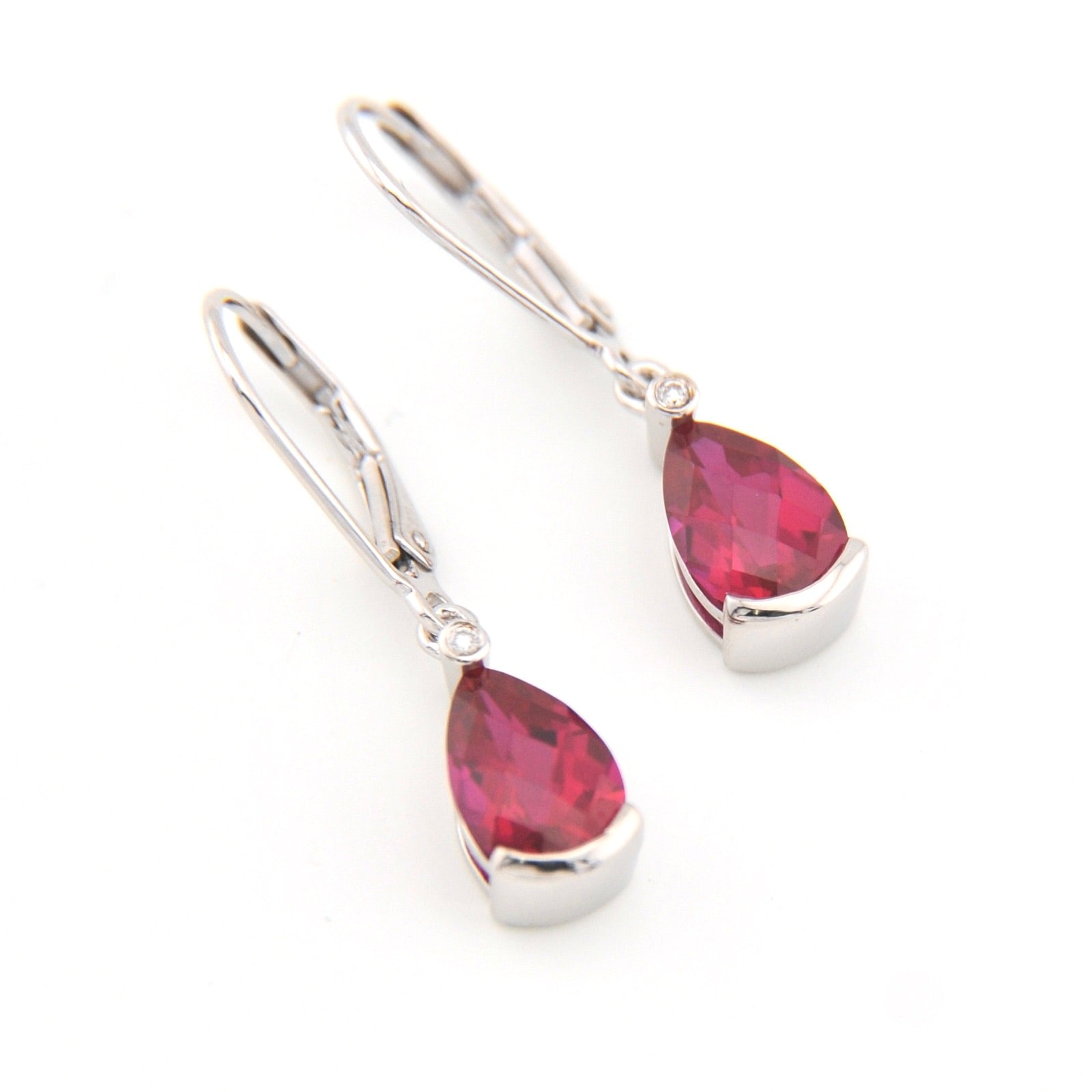 Teardrop-shaped red gemstone earrings with silver hooks on a white background