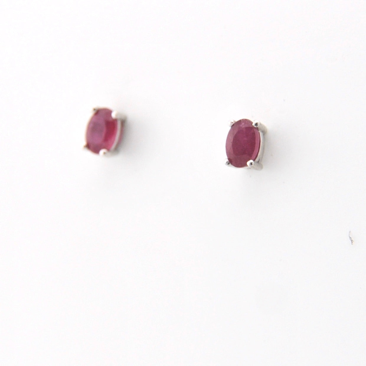 Pair of ruby stud earrings on a white background