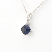 Silver necklace with a blue gemstone pendant on a white background