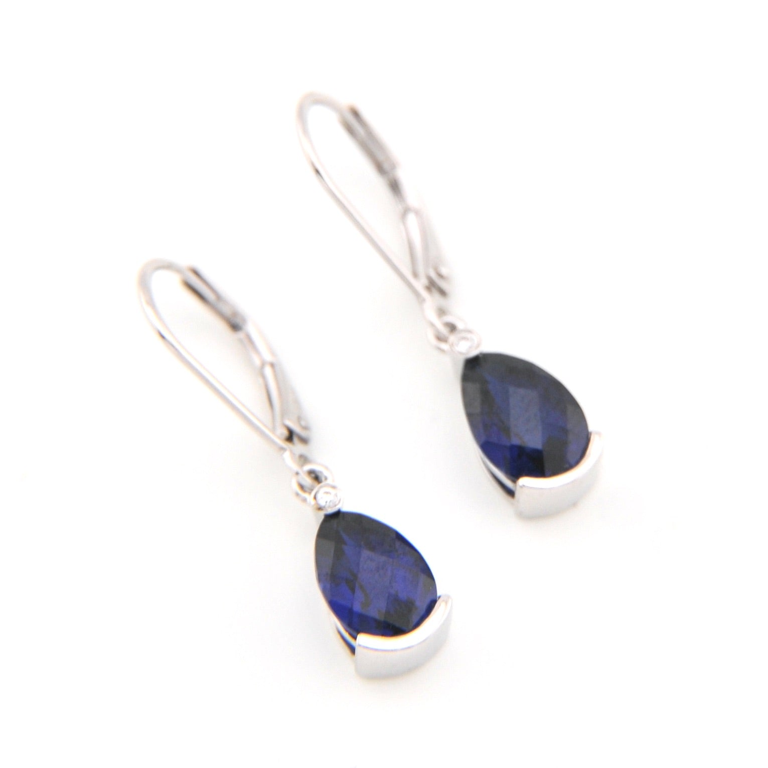 Pair of silver earrings with blue gemstones on a white background