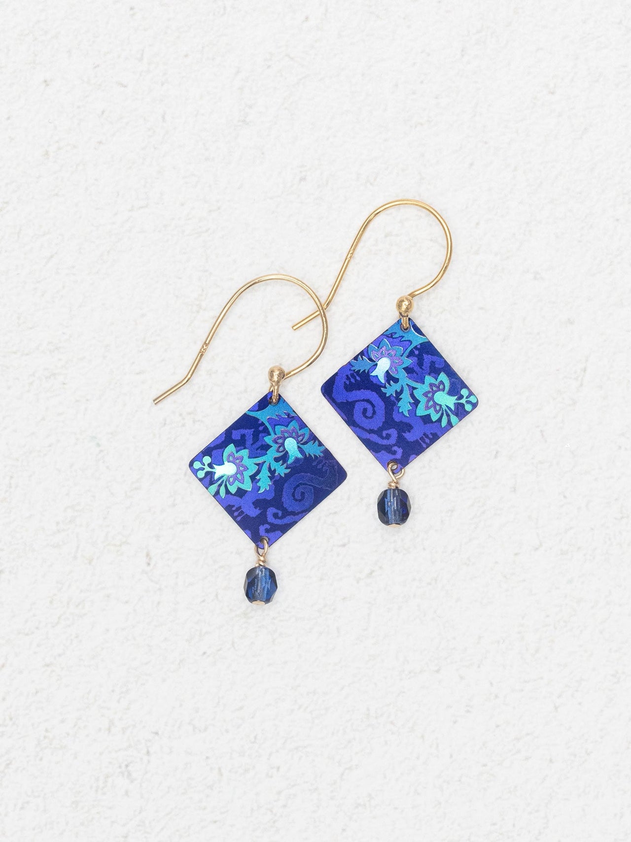 Blue floral patterned earrings on a white background