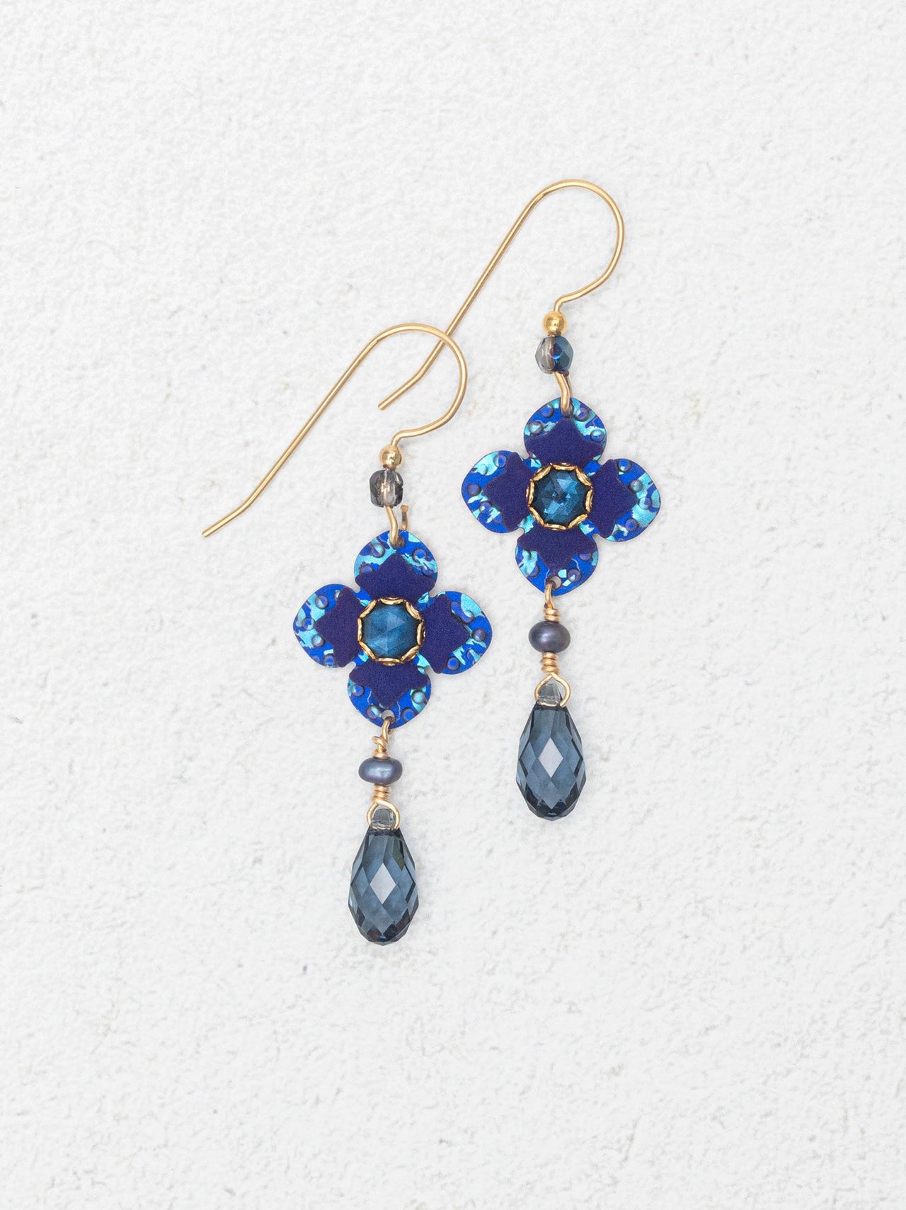 Pair of blue flower-shaped earrings with teardrop beads on a white background