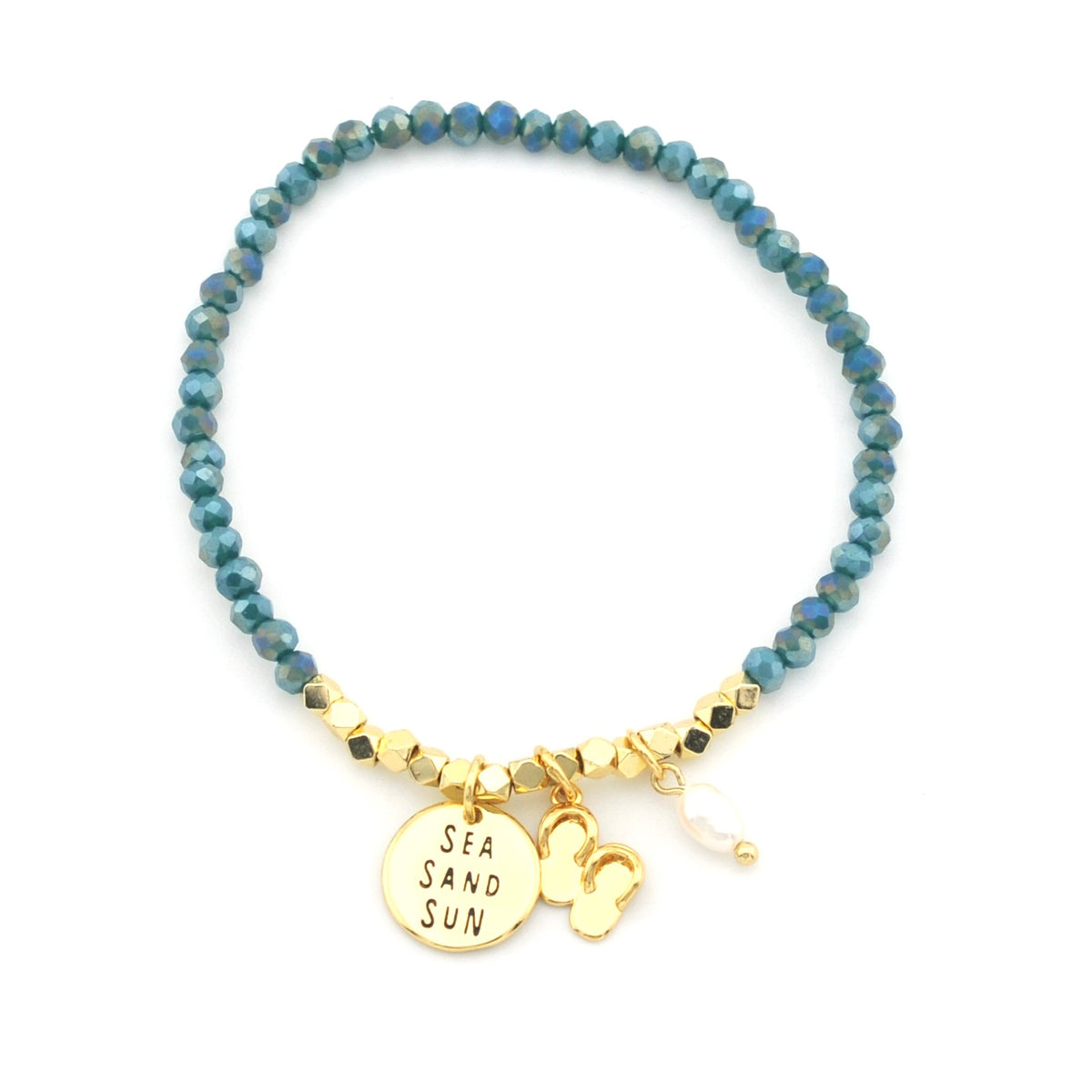 A beaded stretch bracelet featuring faceted blue-green beads, gold spacer beads, and three charms: a round gold disc engraved with 'SEA SAND SUN', a small gold heart, and a tiny white pearl bead.