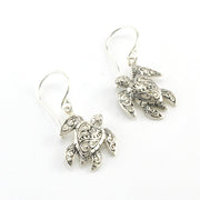 A pair of silver-toned dangle earrings shaped like sea turtles with ornate filigree detailing, shown on a plain white background.