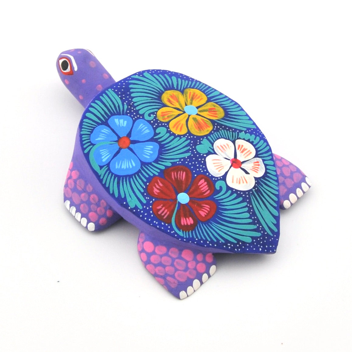 Colorful turtle-shaped object with floral patterns on a white background