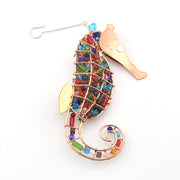 Colorful seahorse-shaped ornament with beads on a white background