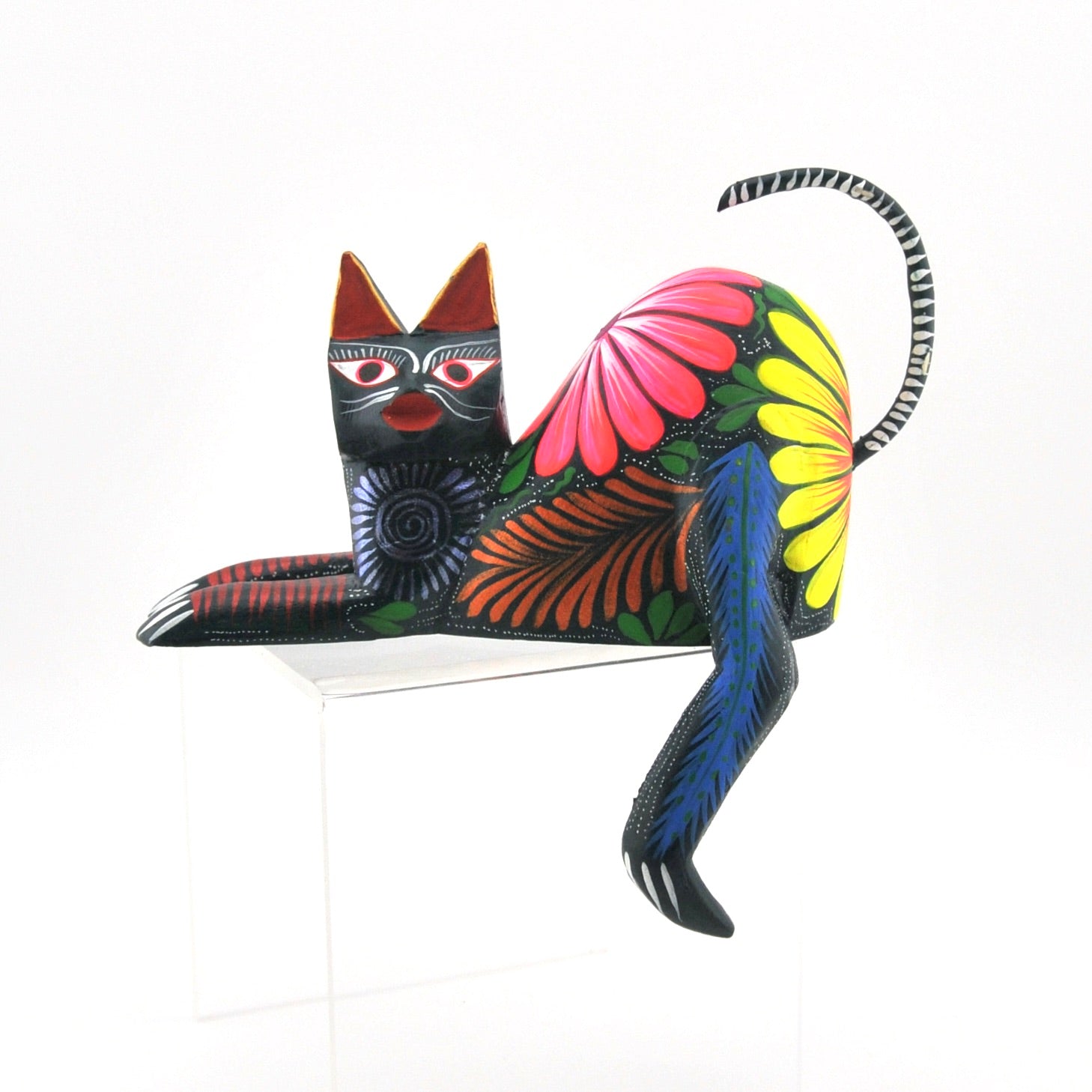 Colorful cat carving with floral patterns on a white background