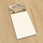 Notepad with beach-themed cover and pencil on a wooden surface