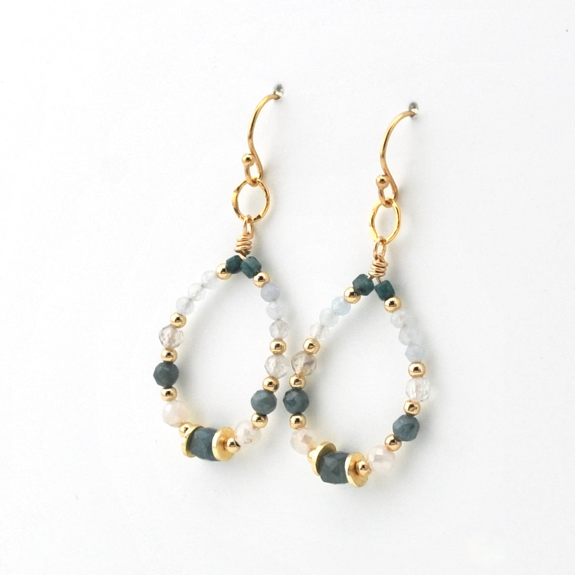 A pair of gold-tone dangle earrings with beaded teardrop-shaped hoops, featuring dark teal, frosted white, and light blue beads on a clean white background.
