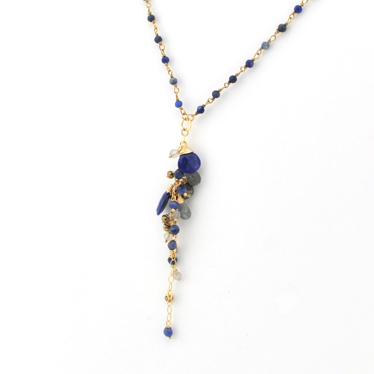A gold chain necklace featuring a dangle pendant made of deep blue lapis gemstone chips and small blue beads, shown against a plain white background.